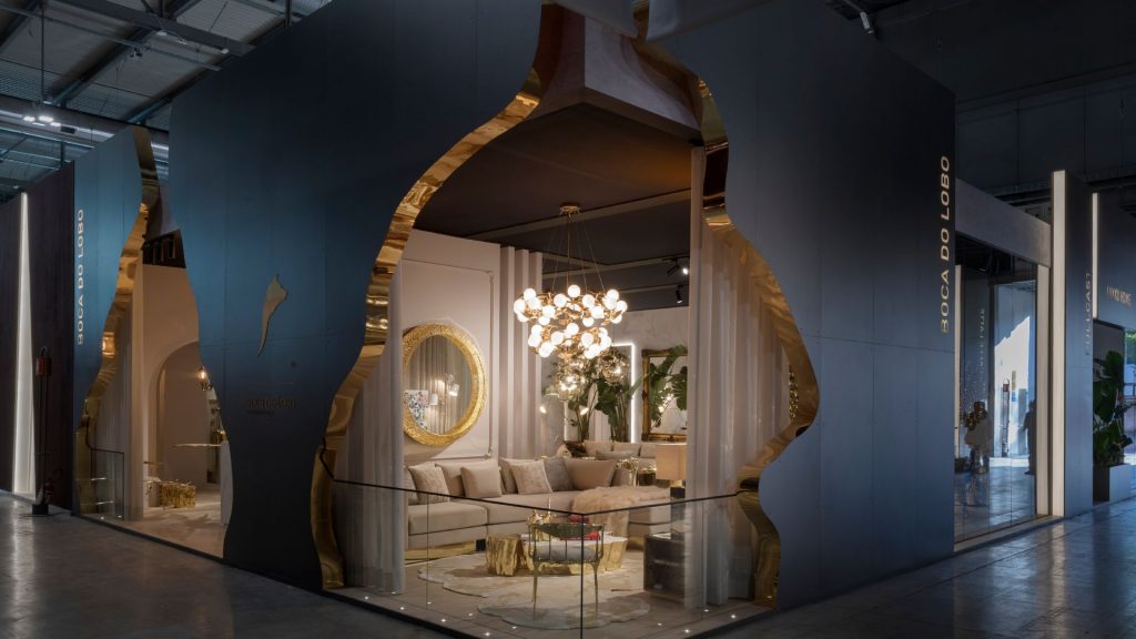 Boca do Lobo- An exhibition with some of our products. There´s a big sofa, a lamp, wood center table , a gold ring miroor